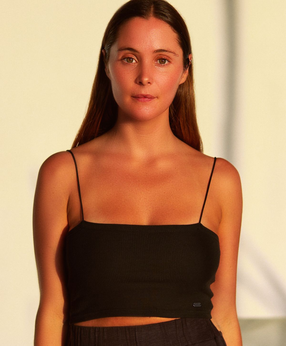 Woman in black crop top, natural lighting.