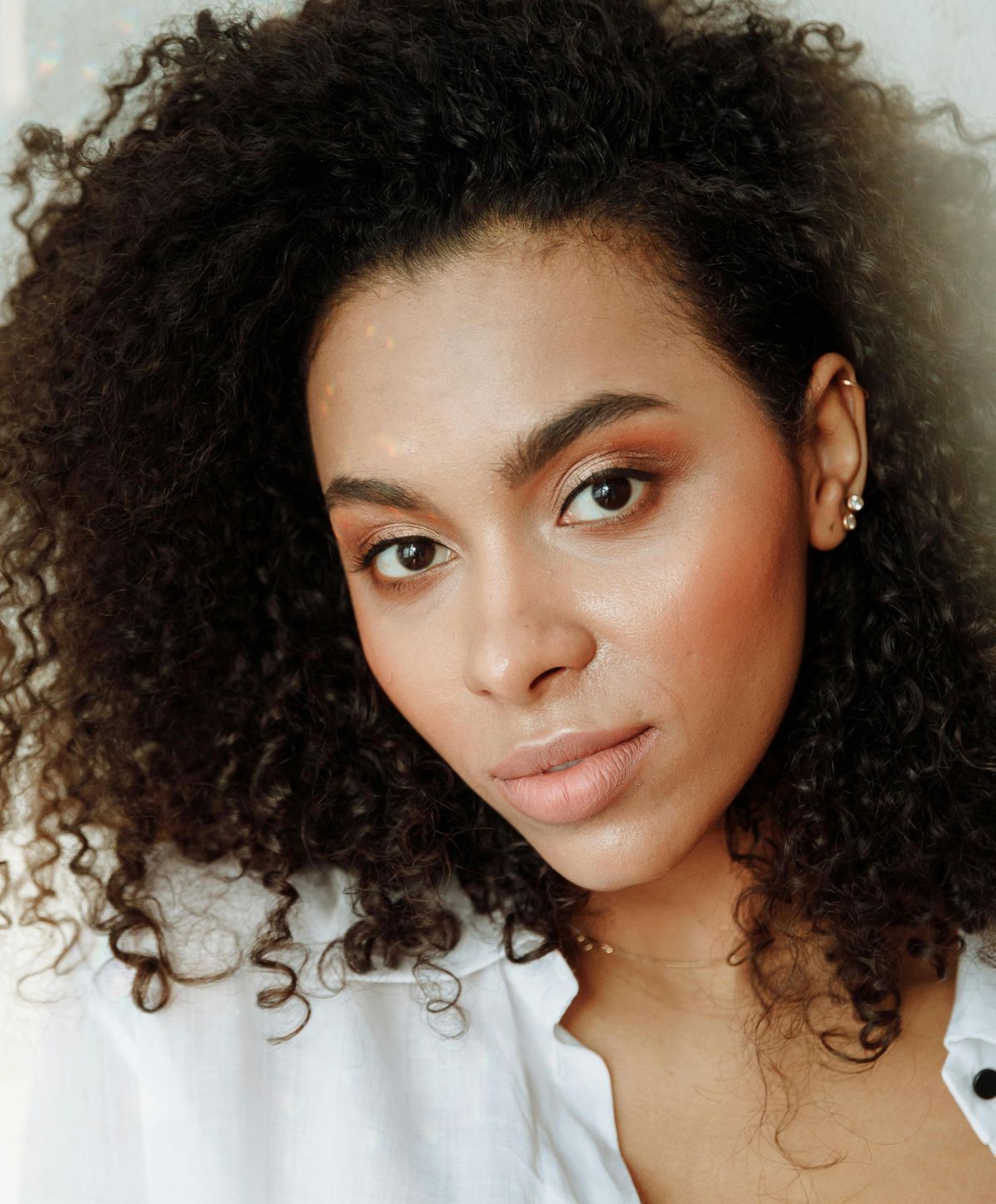 Farmington chin augmentation model with curly hair and natural makeup.