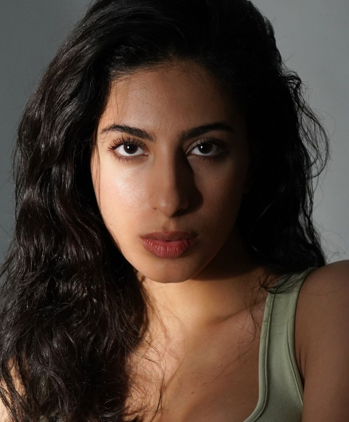 Portrait of a Farmington rhinoplasty model with long, wavy hair.