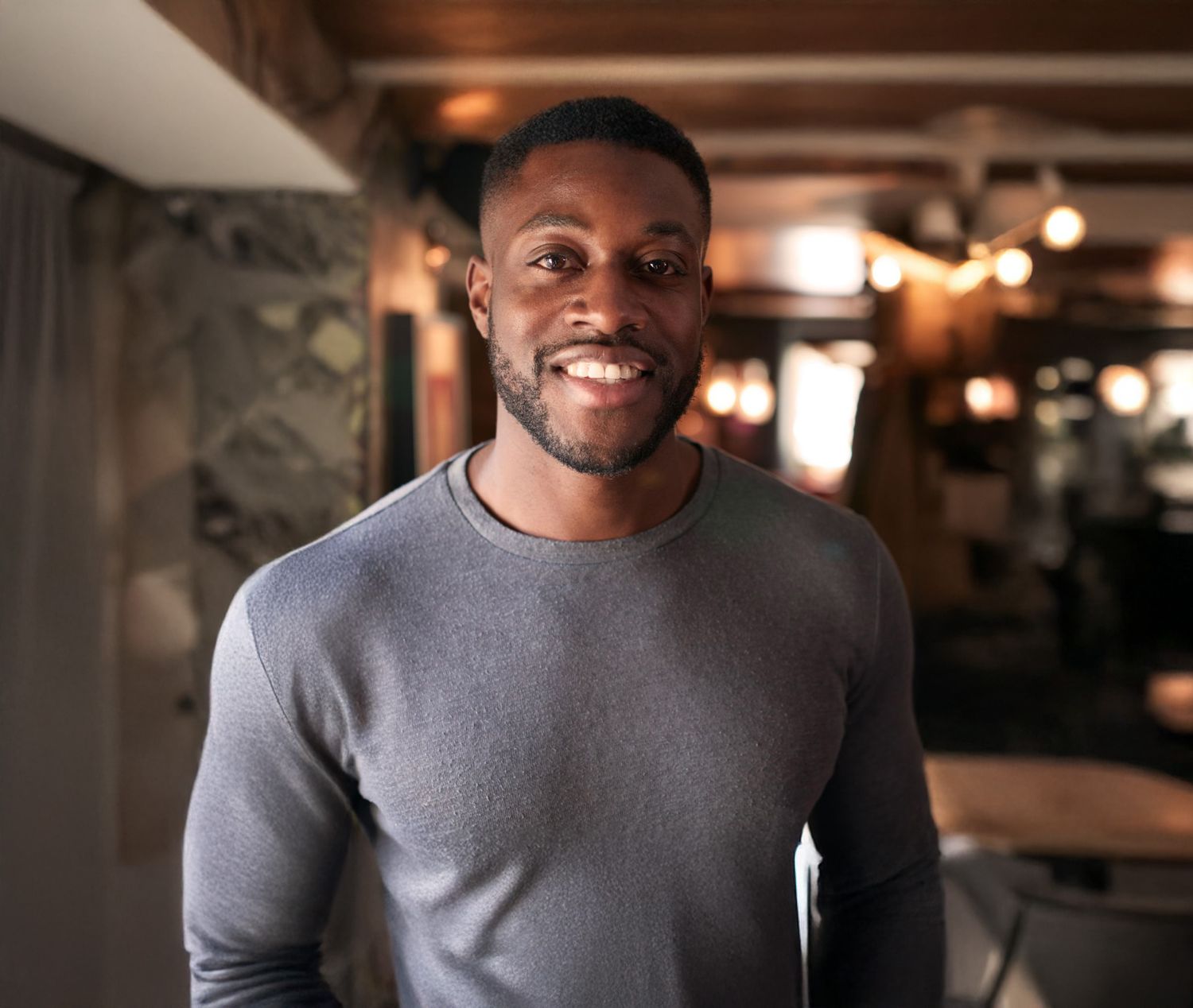 Smiling Avon Renuva model looking out a window.