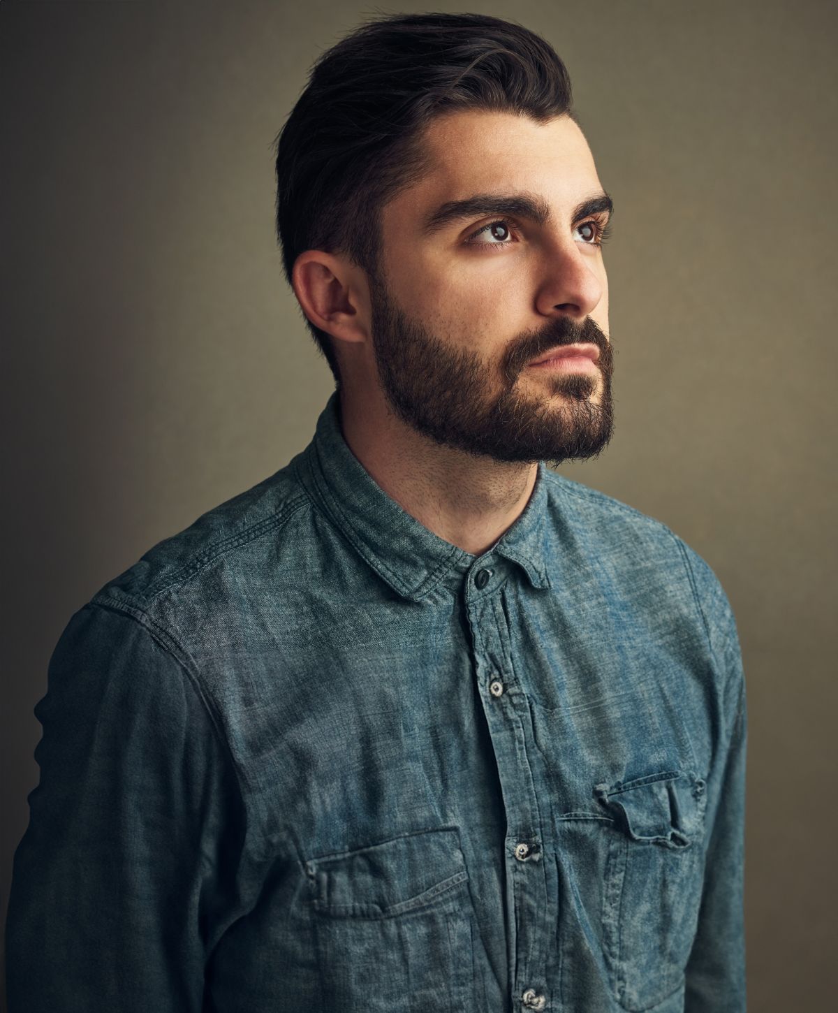 Avon hair restoration model with beard wearing a denim shirt.