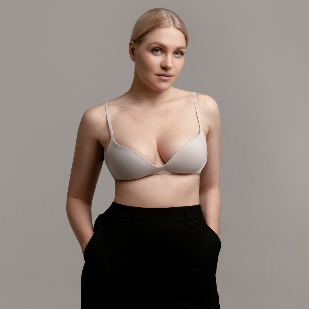 Farmington nipple reduction model in a beige bra and black pants.