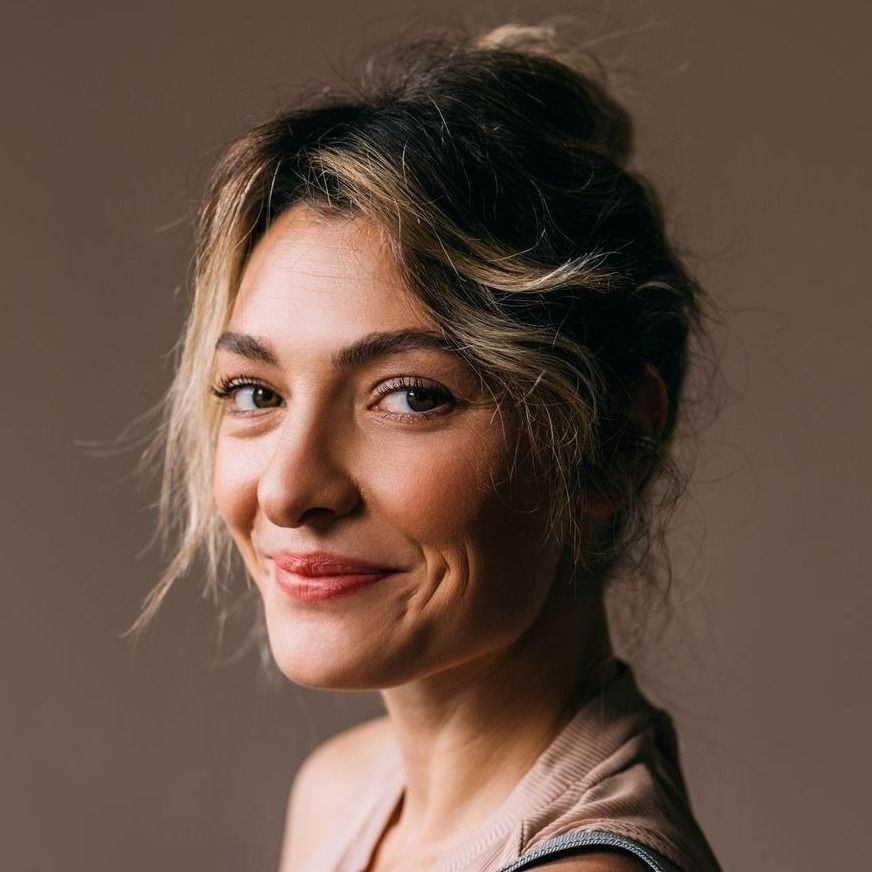 Avon facelift model with wavy hair against neutral background