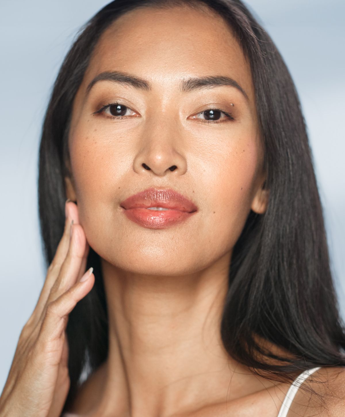 Avon Lutronic Clarity II Laser model with long hair, natural makeup, smiling gently.