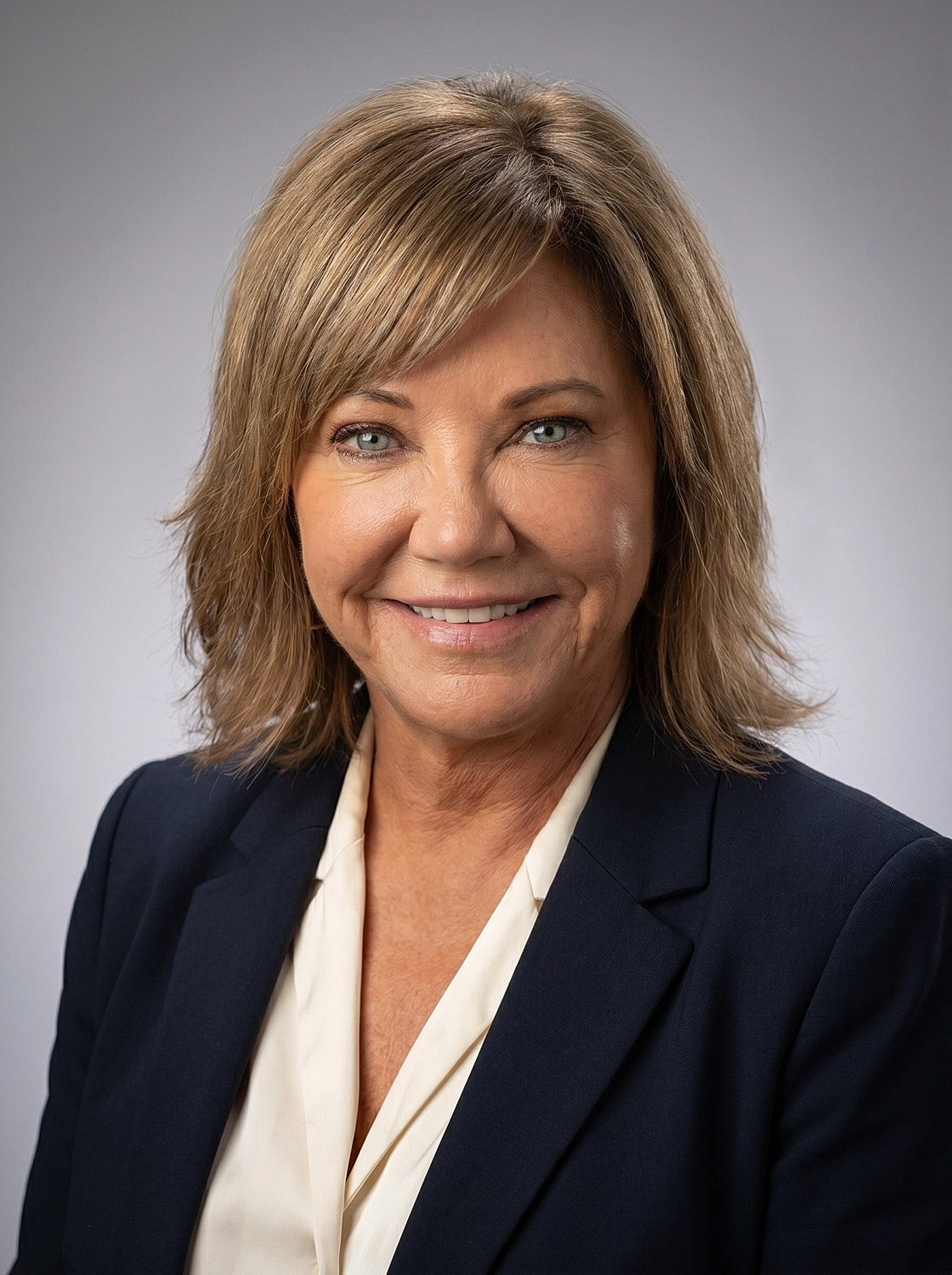 Professional headshot of smiling woman in suit.