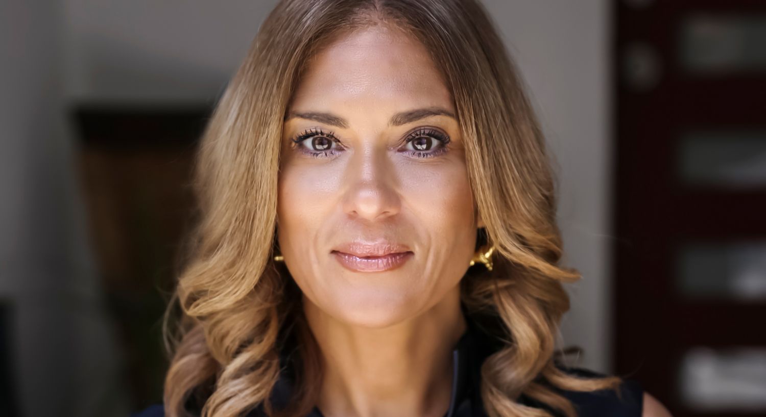 Woman with long hair and a warm expression.