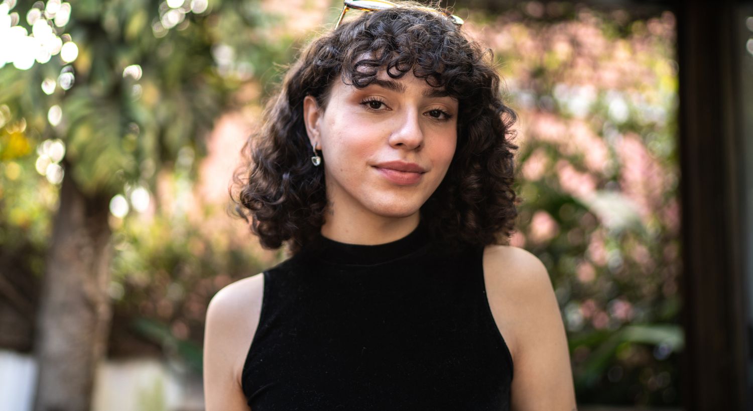 Person with curly hair in outdoor setting.